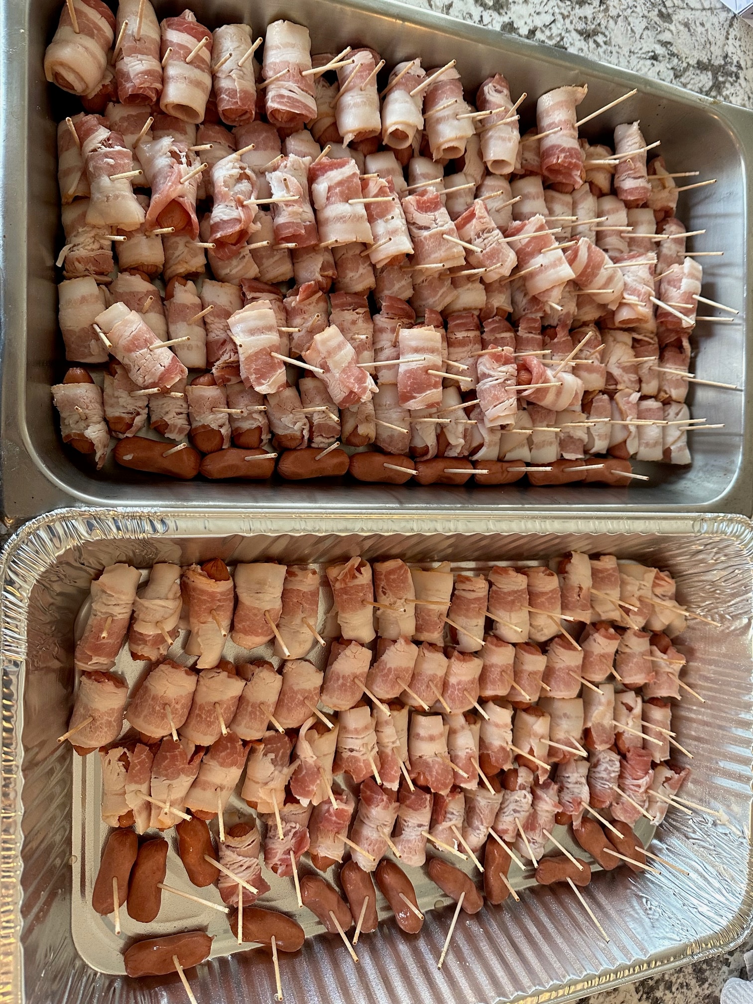 Bacon-wrapped appetizers arranged in catering trays
