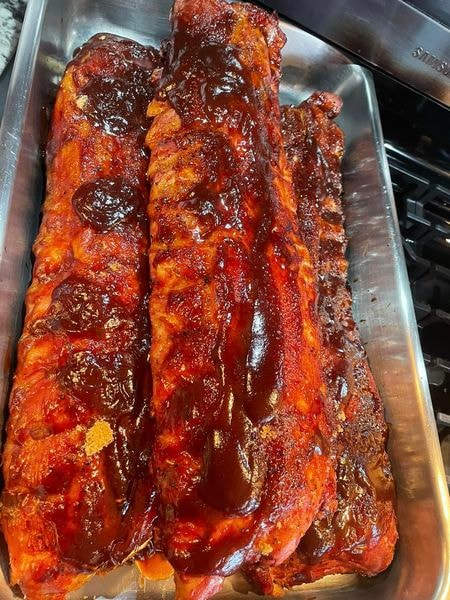 Glazed barbecue ribs in a metal serving tray