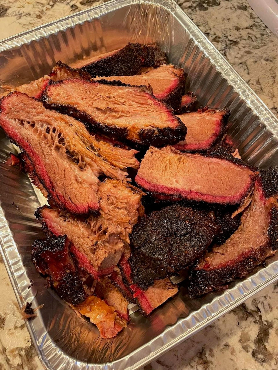 Sliced smoked barbecue brisket in a catering tray