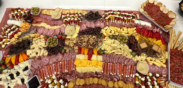 Celebration-ready charcuterie board with cheeses, fruit, and grazing items