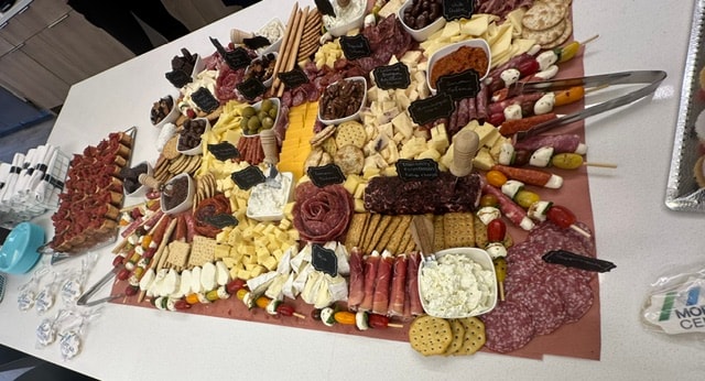 Abundant charcuterie grazing spread with meats, cheeses, fruit, and crackers